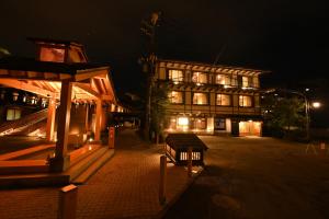 a building at night with a bench in front of it at Ryokan Tamura in Kusatsu