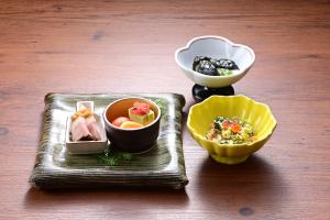 a tray with two bowls of food on a table at Ryokan Tamura in Kusatsu