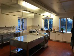a large kitchen with a table in the middle at Hunnebergs Gård Hostel & Camping in Vargön