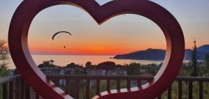 a heart on a balcony with a sunset in the background at Symbola Oludeniz Beach Hotel in Oludeniz