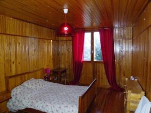 um quarto com uma cama e uma janela com cortinas vermelhas em DUPLEX Les Plautus em Orcières