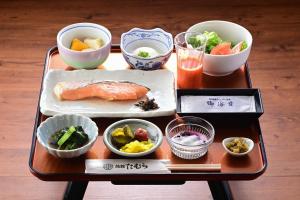 a table with a tray of food and bowls of food at Ryokan Tamura in Kusatsu