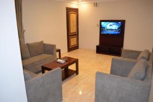 a living room with two chairs and a tv at دانات الخليج in Al Khobar