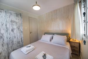 een slaapkamer met een bed met handdoeken erop bij The Beach House-Valley of love in Episkopos