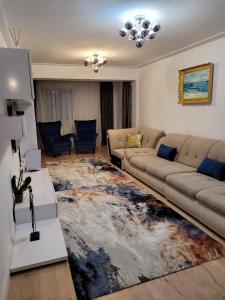 a living room with a couch and a rug at Neversea Apartment in Constanţa