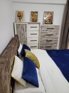 a bedroom with a bed with blue and white pillows at Neversea Apartment in Constanţa