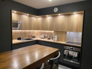 cocina con encimera de madera y mesa de madera en Superbe appartement, grande terrasse vue mer et montagne, en San Juan de Luz