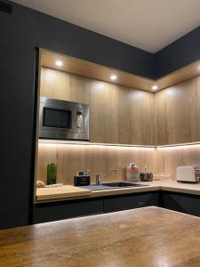 a kitchen with a sink and a microwave at Superbe appartement, grande terrasse vue mer et montagne in Saint-Jean-de-Luz