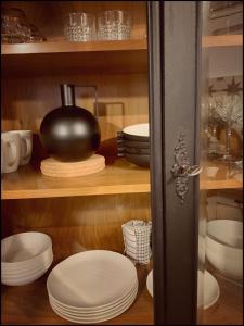 um armário cheio de pratos brancos e um pote em Casa Corner em Vrsar