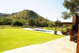 a backyard with a pool and a grass yard at Chargo Boutique Lodge in Colesberg