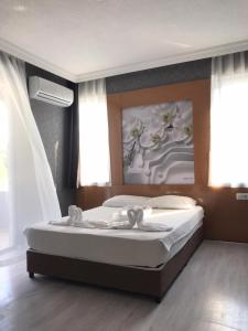 a bedroom with a bed with a painting on the wall at Anita Kemer Noch Hotel in Kemer