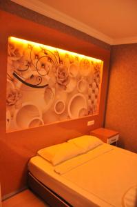 a bedroom with a wall with a painting of cups at Anita Kemer Noch Hotel in Kemer