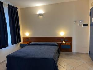 1 dormitorio con 1 cama con manta azul y escritorio en 1000 Miglia, en Monteroni dʼArbia
