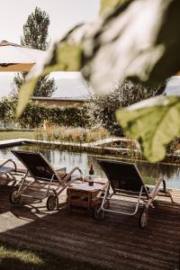 two chairs and a table next to a lake at Weingut Kollerhof am Eichberg in Leutschach