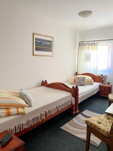 a bedroom with two beds and a table at 2- posteľová izba s kúpeľňou EMKA v PENZION TRSTENÁ in Trstená