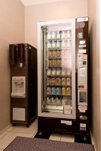 a refrigerator with drinks in it next to a water cooler at Dormy Inn Nagasaki Shinchichukagai in Nagasaki