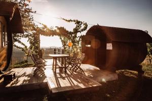 a table and a chair on a deck with a tree at Weingut Kollerhof am Eichberg in Leutschach