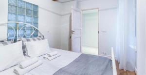 - une chambre blanche avec un grand lit et un miroir dans l'établissement Karusselli Apartment, à Pärnu