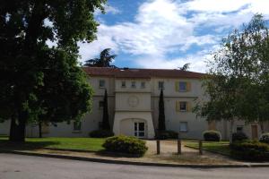 a large building with a tree in front of it at Chambre d'hôte Les Cottages de Sainte Émilie in Annonay