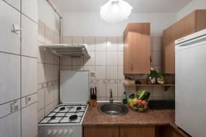 a small kitchen with a sink and a stove at ShortStayPoland Darwina (B9) in Warsaw