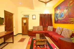 a living room with a red couch and a painting at villa Freddy in Puducherry