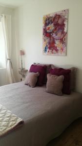 a bed with two pillows and a painting on the wall at GÎTE AU TILLEUL pour 8 personnes in Mariac +19 photos