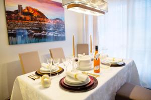 a table with a white table cloth with plates and glasses at LUXURY New Apartment CITY CENTRE & BEACH, Alicante in Alicante