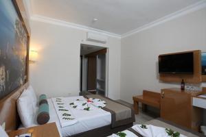 a hotel room with a bed and a flat screen tv at Anita Dream Hotel in Kemer