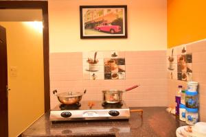 a kitchen with a stove with two pots on it at Villa Freddy Individual 2 BHK Properties at Second Floor with Modern Amenities in Puducherry +17 photos