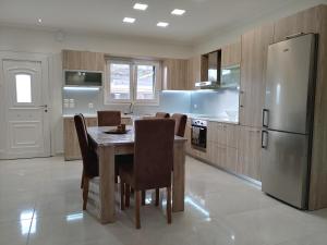 a kitchen with a table and chairs and a refrigerator at Stefanos' Apartment in (( Litherés ))