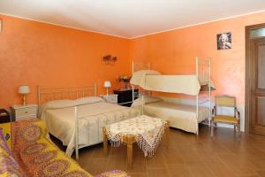 sypialnia z 2 łóżkami i pomarańczową ścianą w obiekcie Villa Rosa w mieście Porto Empedocle