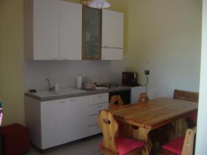 une cuisine avec des placards blancs et une table en bois dans l'établissement Cluana Azienda Agrituristica, à SantʼElpidio a Mare