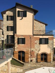 un gran edificio de ladrillo con puertas y balcón en Villa Sutherland Piemonte with private pool, en Montaldo Bormida