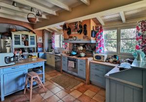 a large kitchen with blue cabinets and counters at Xenonerantzia Country style villa in Gouvia