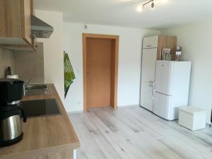 een keuken met een witte koelkast en een houten vloer bij Ferienwohnung Jump INN in Kurort Oberwiesenthal