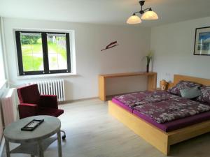 een slaapkamer met een bed, een tafel en een stoel bij Ferienwohnung Jump INN in Kurort Oberwiesenthal