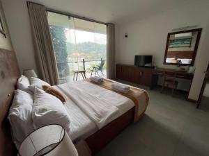 a bedroom with a large bed and a balcony at Lotus Lake Residence in Kandy