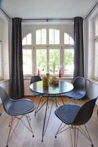 開姆尼茨的住宿－Stylisches City Appartment in Chemnitz bester Lage!，一间带桌子和四把椅子的用餐室