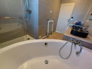 a white bath tub in a bathroom with a sink at Superbe appartement au centre de St Jorioz in Saint-Jorioz +16 photos