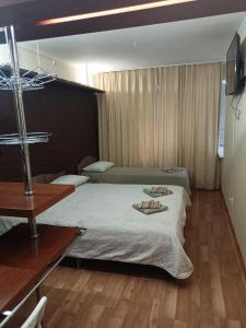 a bedroom with a large bed and a wooden floor at SPACE Aparts and Rooms in Yekaterinburg
