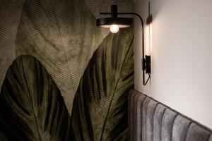 a wall mounted lamp with a leaf design on a wall at Amery House in Sliema