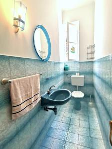 ein Badezimmer mit einem Waschbecken, einem WC und einem Spiegel in der Unterkunft Apartman Villa Adelina in Lovran