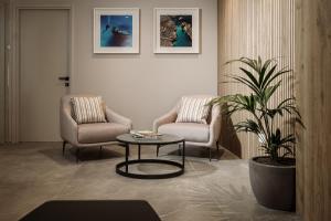 a room with two chairs and a table and a plant at Amery House in Sliema