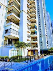 a large building with a swimming pool in front of it at Flat de luxo São Paulo - Guarulhos in Guarulhos