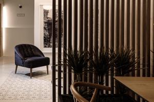 a room with a chair and a table and plant at Amery House in Sliema