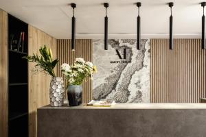 a counter with flowers in a vase on it at Amery House in Sliema +37 photos