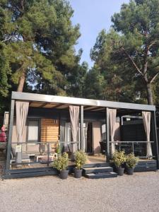 una casa pequeña con porche y cortinas en Hemy Casa - Lux Mobile Homes en Rovinj