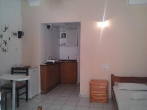 a room with a kitchen and a bedroom with a table at Studio 10 minutes from the center of Heraklion. in Heraklio