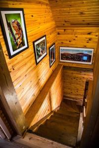 a staircase in a wooden cabin with pictures on the wall at Chalet des Hauts- Vue piton des neiges in Le Tampon
