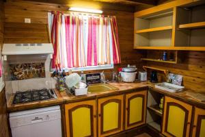 une cuisine avec évier et cuisinière ainsi qu'une fenêtre dans l'établissement Chalet des Hauts- Vue piton des neiges, à Le Tampon